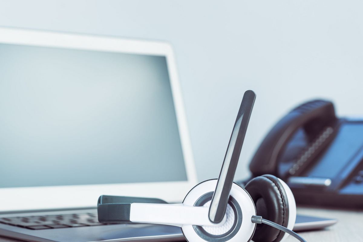Customer service representative wearing a headset while taking calls in a call center.