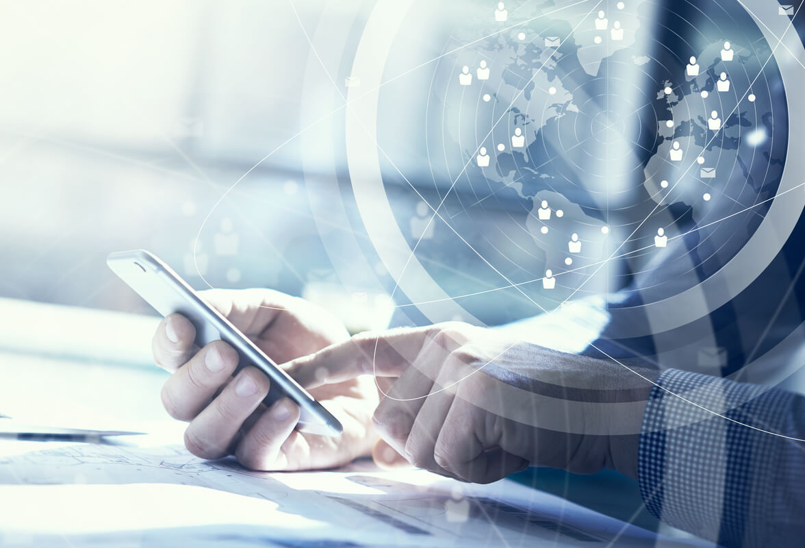 A person holds a smartphone, engaging with digital content. Overlaid are graphics of a world map and network icons, symbolizing global connectivity. 