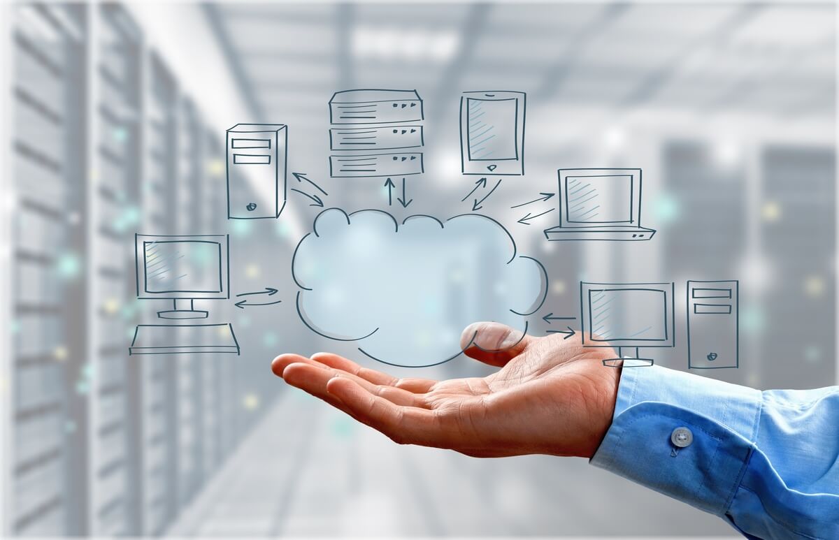 A hand supporting a cloud graphic with arrows connecting to doodles of servers, computers, and devices, symbolizing cloud computing in a data center.