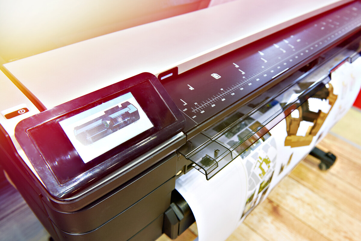 A large-format printer produces vibrant, colorful images on paper. 